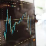 Detailed view of financial trading graphs on a monitor, illustrating stock market trends.