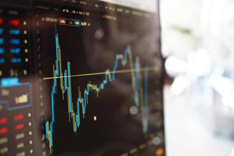 Detailed view of financial trading graphs on a monitor, illustrating stock market trends.